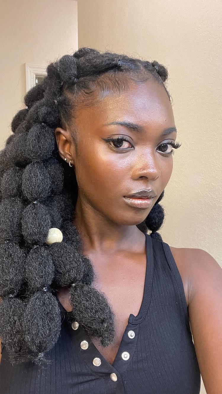12 Braids Hairstyles: 16 Ideas From Box Braids to Cornrows 15 Woman with thick black bubble braids and a white bead in her hair.