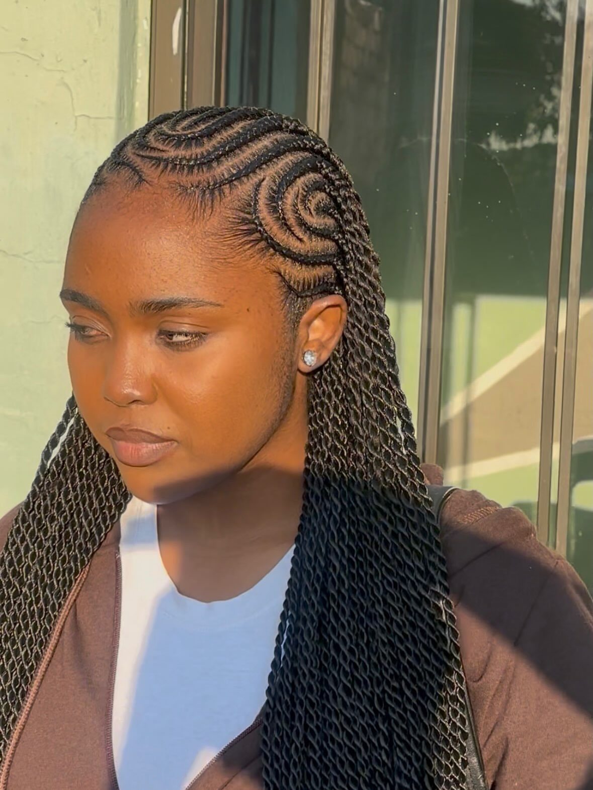 12 Braids Hairstyles: 16 Ideas From Box Braids to Cornrows 7 Woman with curved cornrow patterns transitioning into long black individual braids.