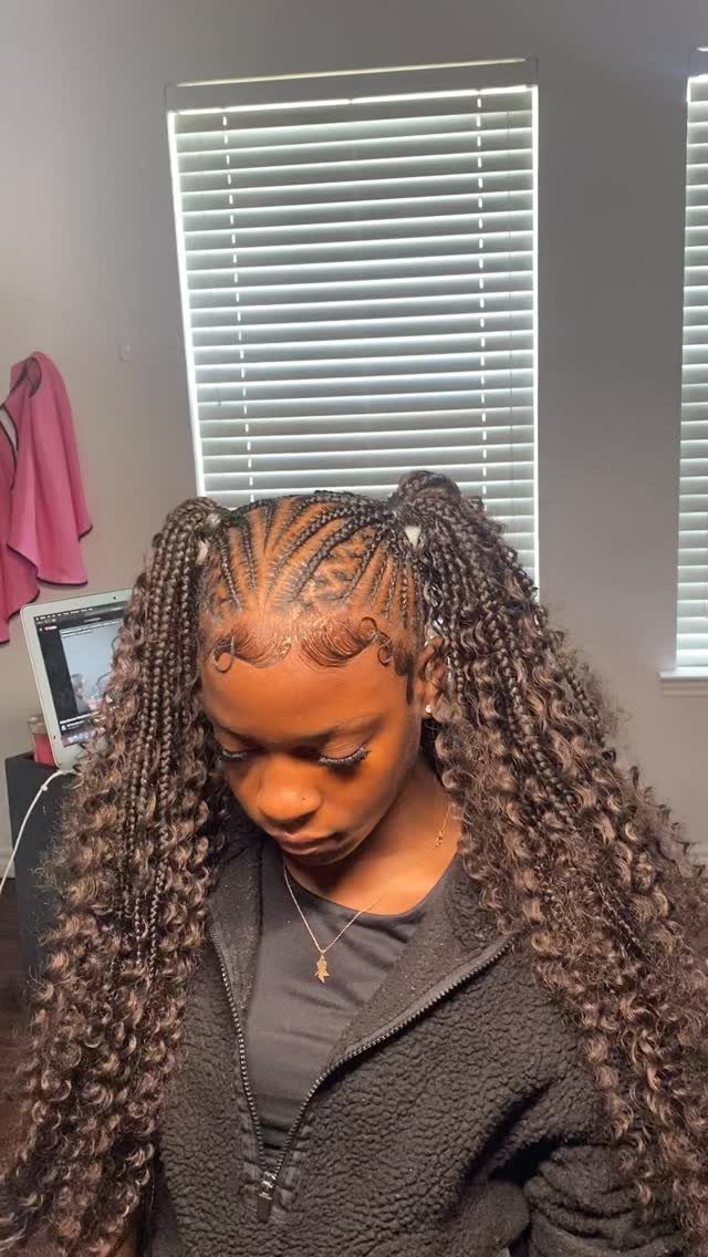 Woman with two high boho braids featuring long curly extensions and laid edges.