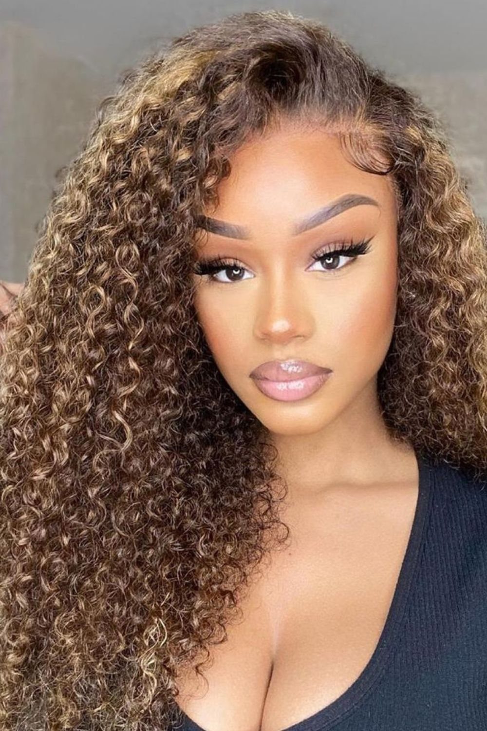 33 Hair Color vs. Color 5: 5 Ideas for Braids and Curls 3 Woman with medium skin tone and long curly golden-brown hair posing for portrait