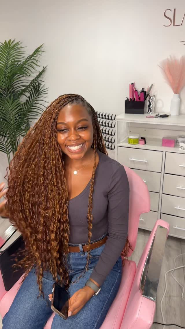33 Hair Color vs. Color 5: 5 Ideas for Braids and Curls 5 Woman with long auburn curly braids smiling in a pink salon chair