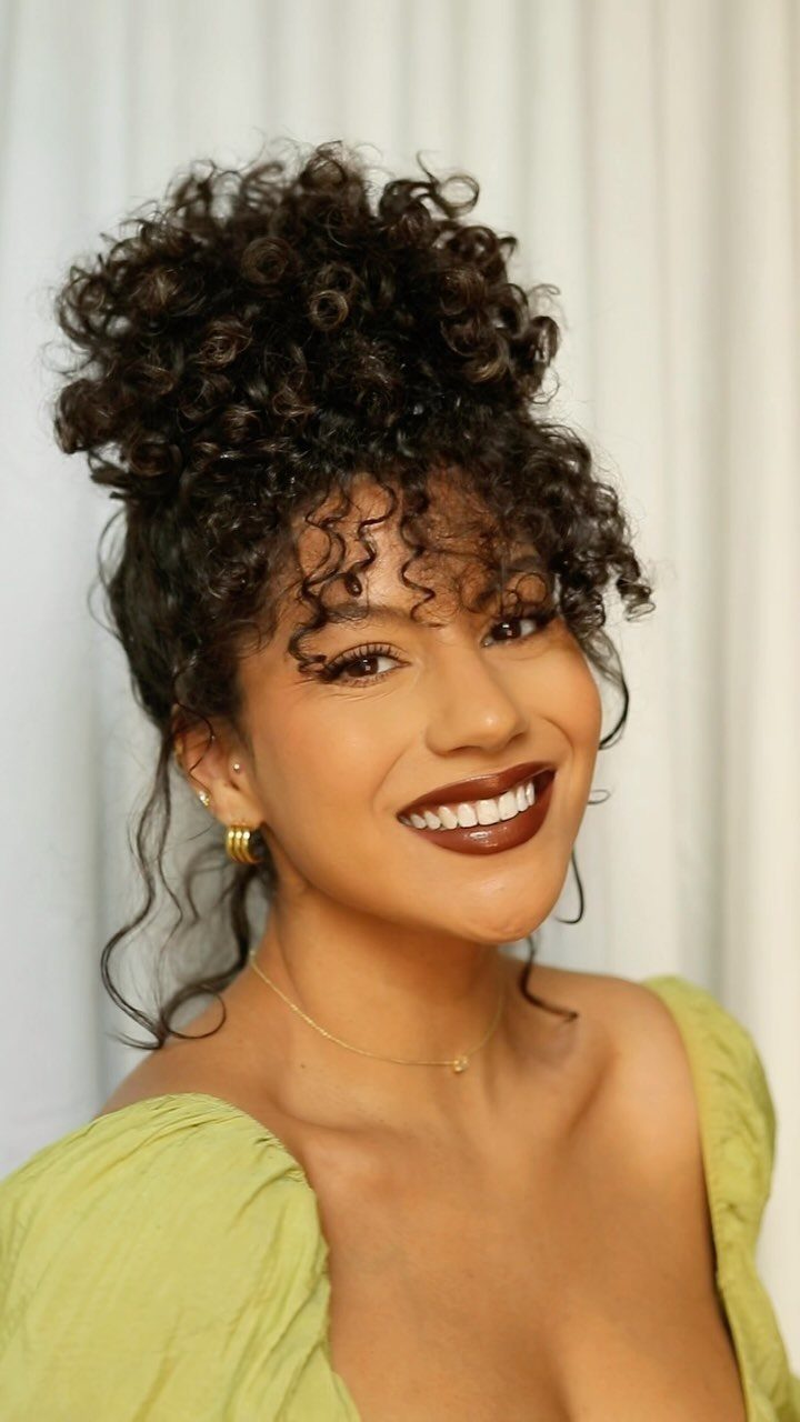 3A Hair Long: 4 Ideas for Pineapples, Ringlets and More 1 Woman with curly hair styled in a high pineapple updo and curly bangs.