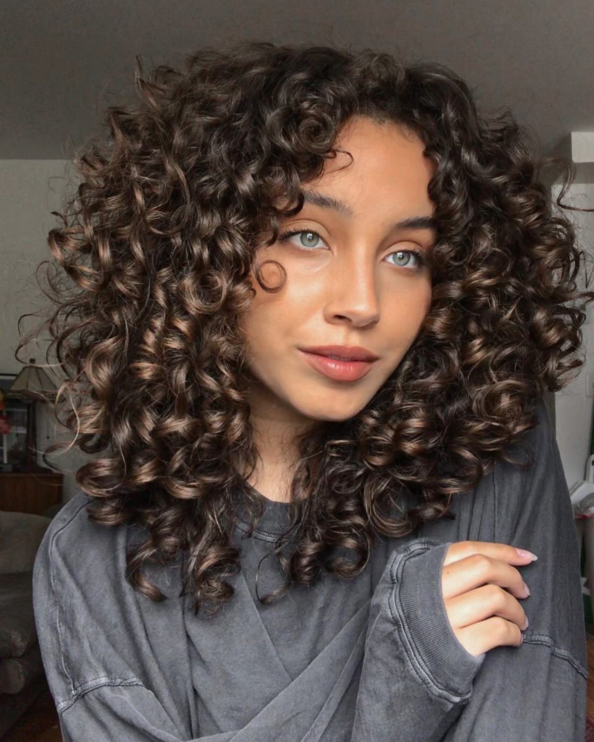 3A Hair Long: 4 Ideas for Pineapples, Ringlets and More 4 Woman with long, voluminous brown curly hair and blue eyes posing for portrait