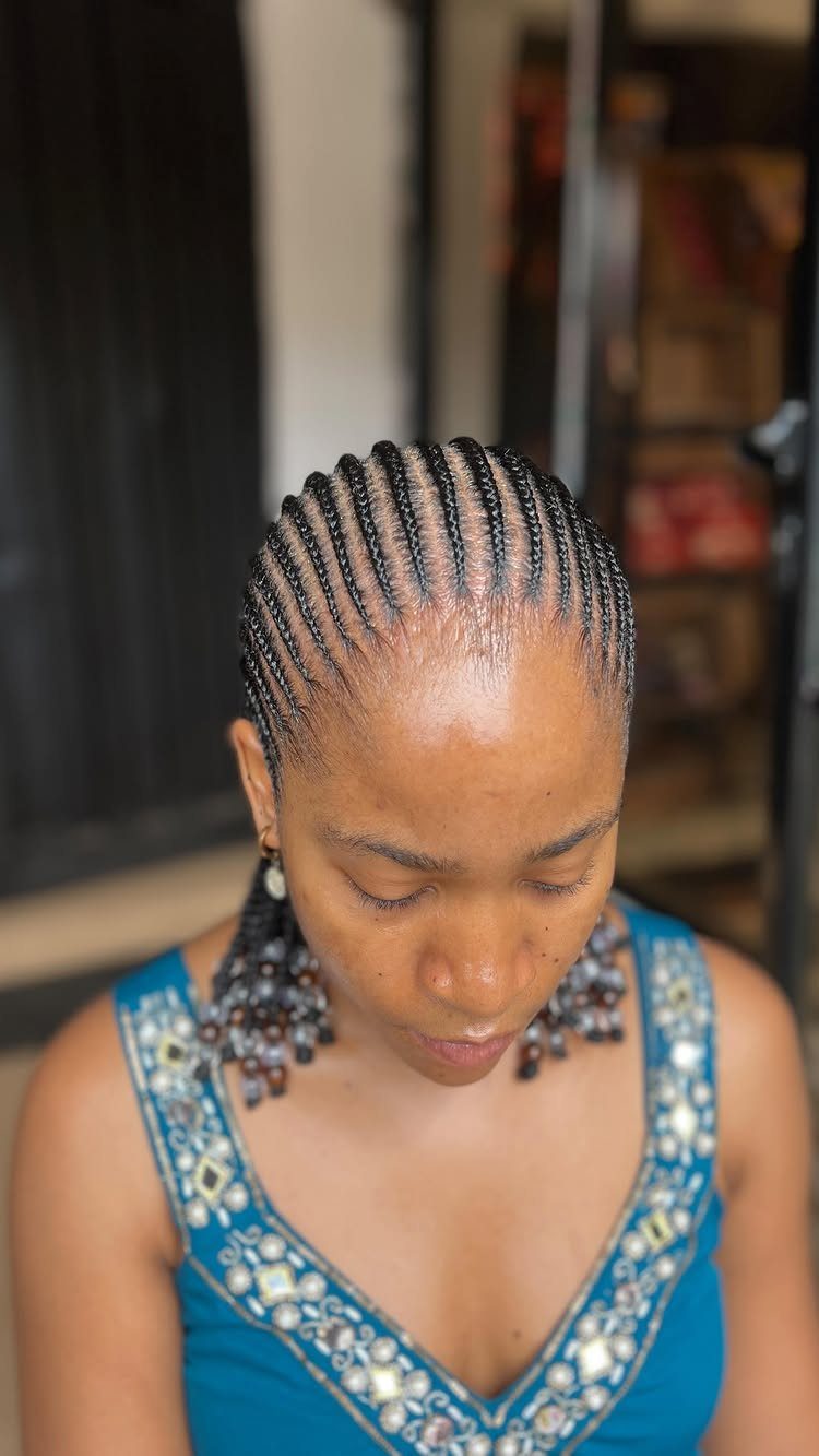16 Big Cornrow Hairstyles for Bold, Standout Looks 1 Woman with straight-back cornrows adorned with brown and clear decorative beads.