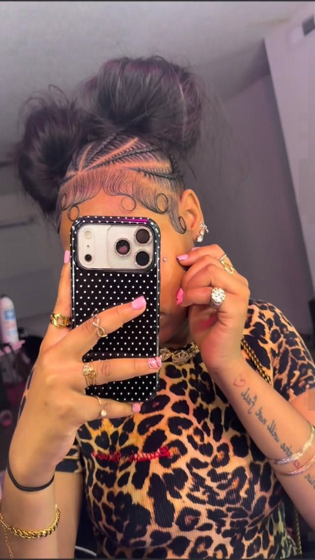 16 Big Cornrow Hairstyles for Bold, Standout Looks 9 Woman with cornrows styled into a large bun wearing leopard print clothing.