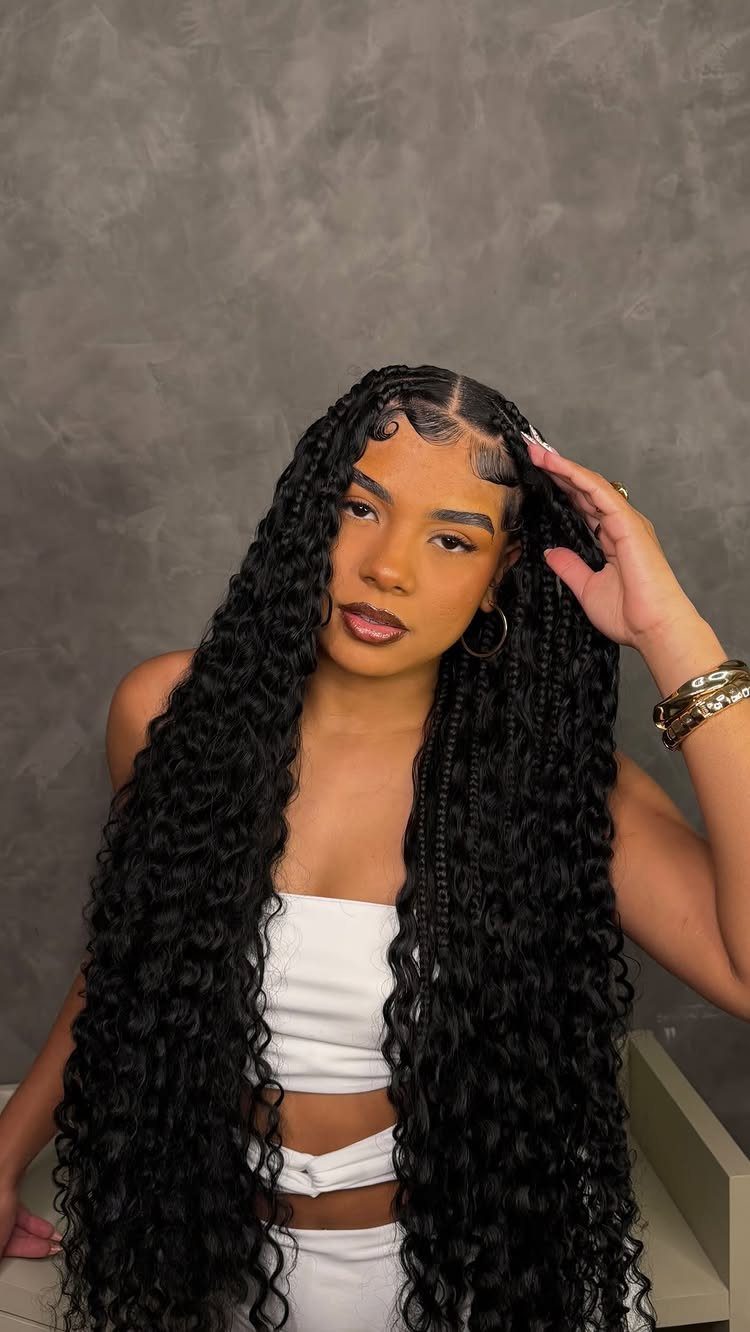 16 Big Cornrow Hairstyles for Bold, Standout Looks 7 Woman with long black goddess braids and curly tendrils wearing a white top.