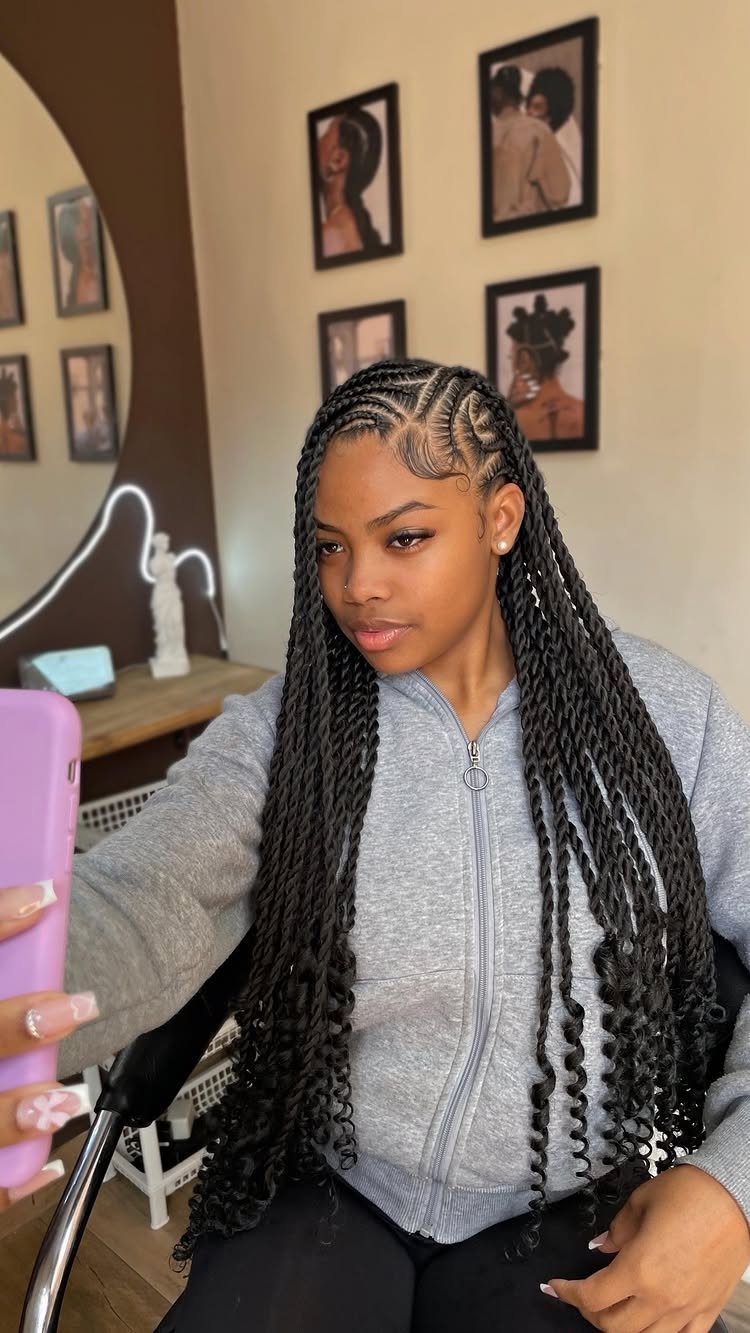 16 Big Cornrow Hairstyles for Bold, Standout Looks 2 Woman with long black twisted cornrows ending in curls wearing a grey hoodie.