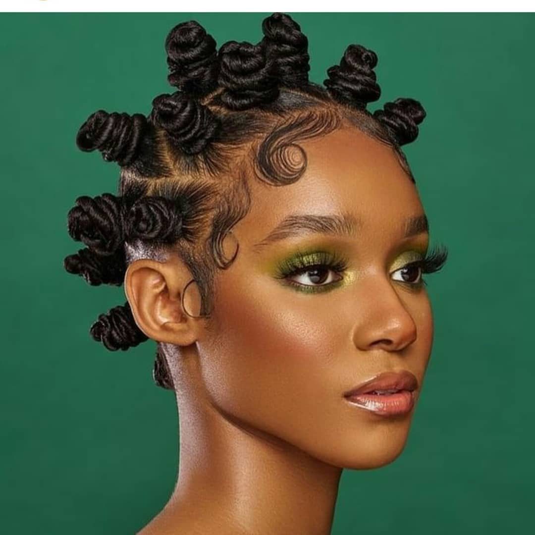 31 Black Hair Natural Hairstyles for Every Length 9 Woman with dark skin featuring black hair styled in coiled Bantu knots.