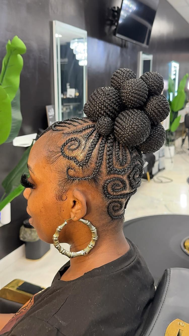 31 Black Hair Natural Hairstyles for Every Length 5 Woman with intricate swirling cornrows styled into a high braided bun updo.