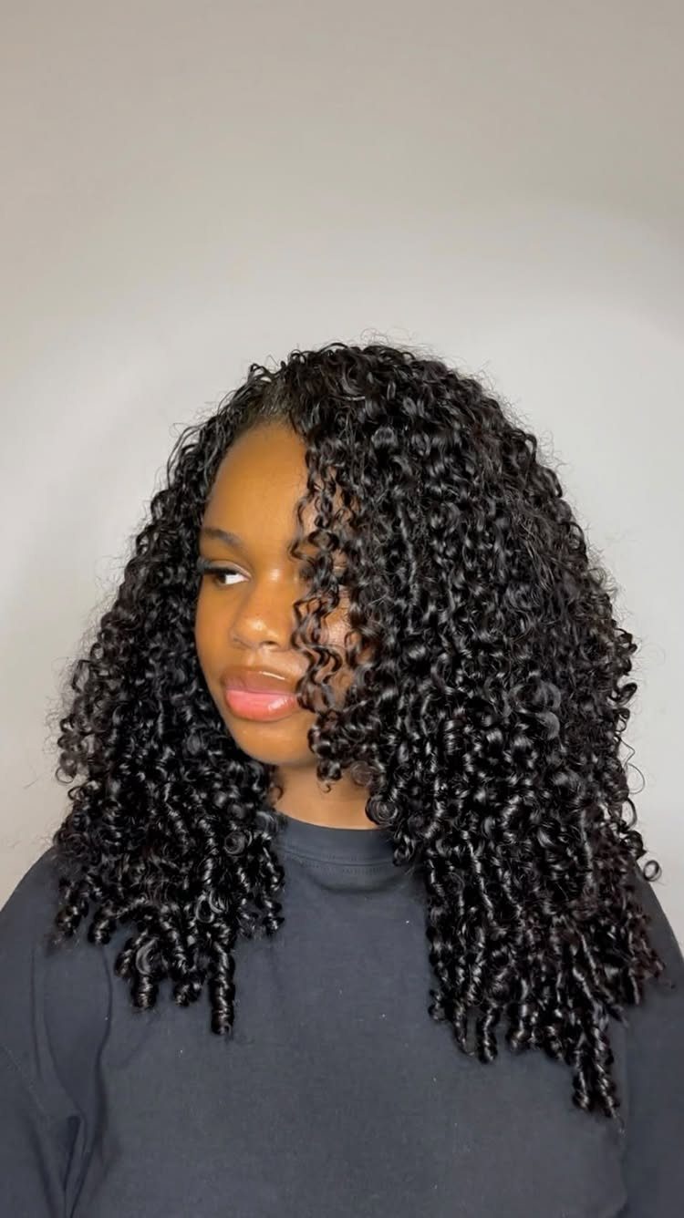 31 Black Hair Natural Hairstyles for Every Length 15 Woman with long, voluminous black hair featuring tight, defined curly ringlets.