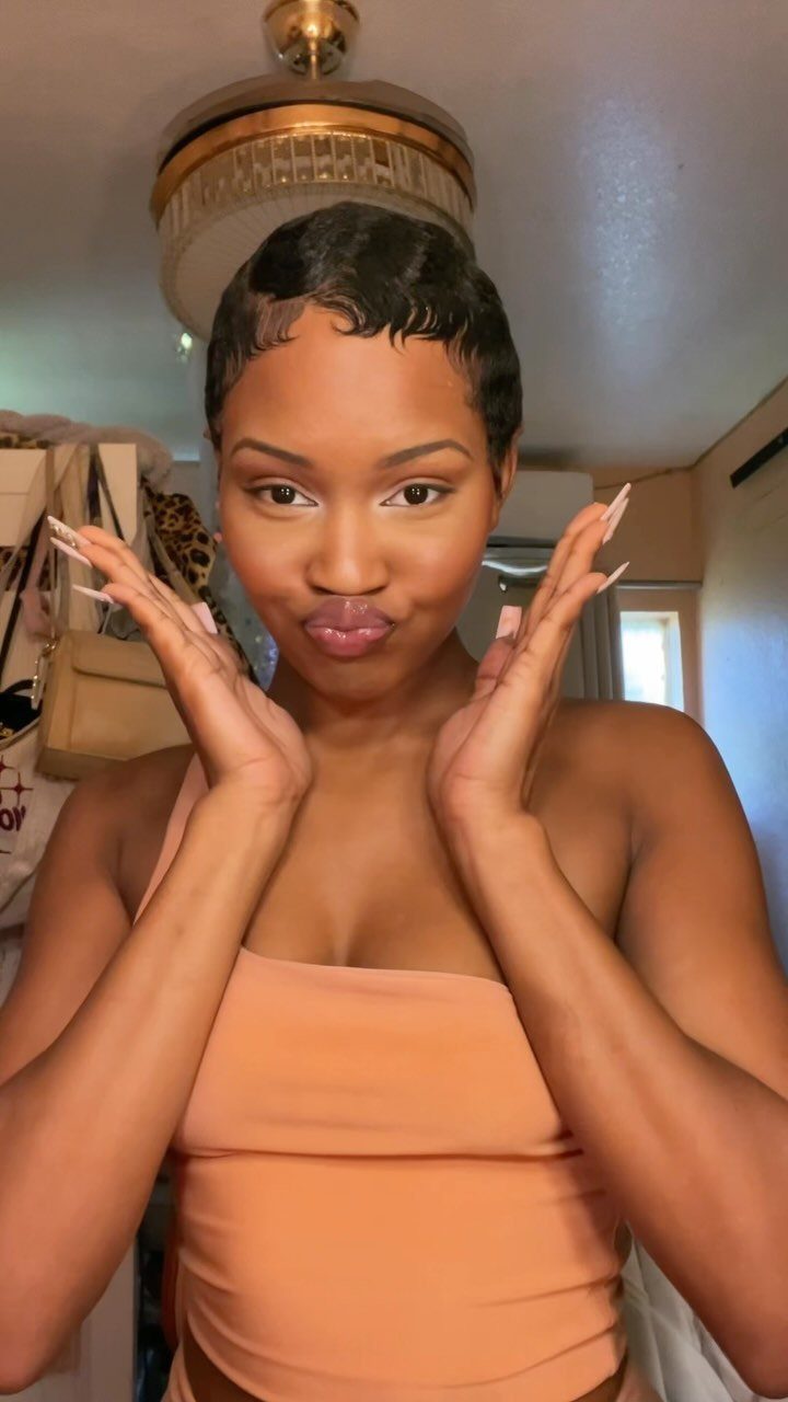 31 Black Hair Natural Hairstyles for Every Length 22 Woman with short black hair styled in elegant finger waves wearing peach top.