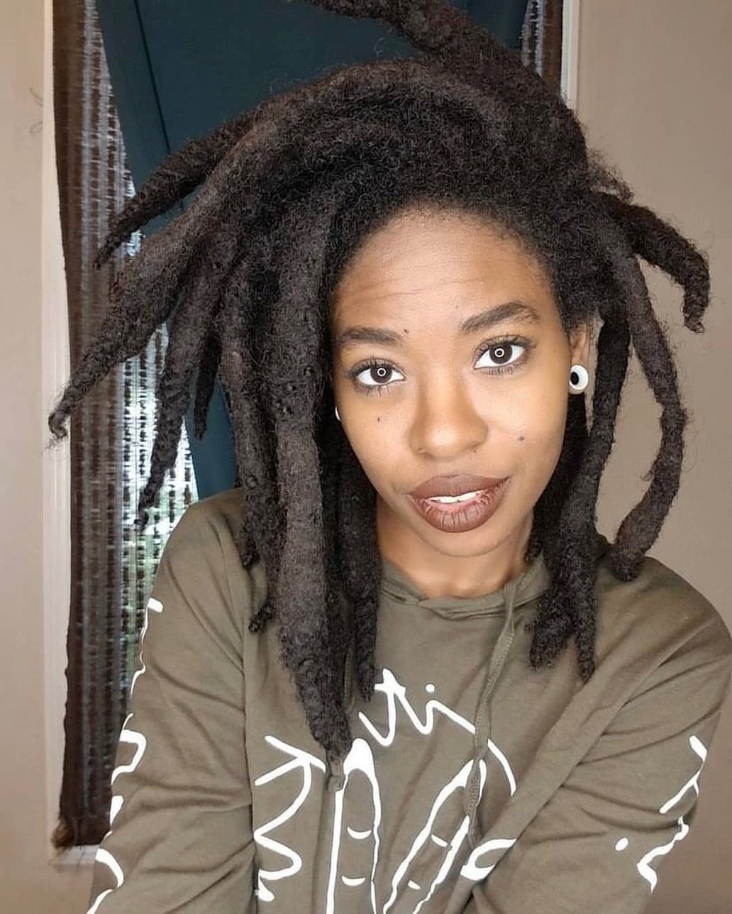 31 Black Hair Natural Hairstyles for Every Length 20 Woman with long, thick freeform locs wearing an olive green graphic hoodie.