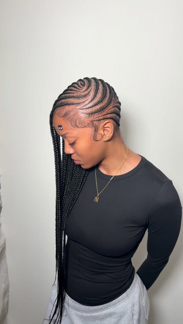 31 Black Hair Natural Hairstyles for Every Length 8 Woman with side-swept lemonade braids wearing a black shirt and gold necklace.