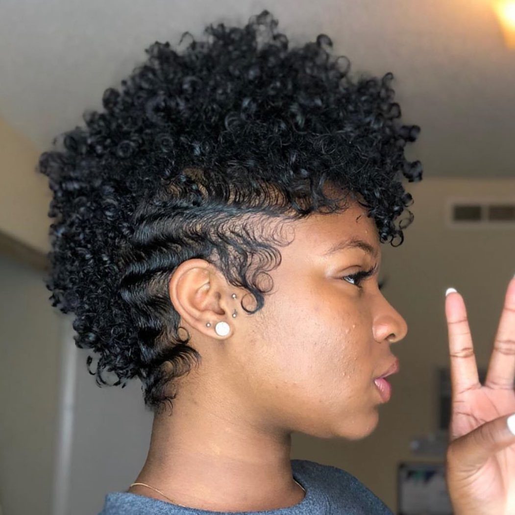 31 Black Hair Natural Hairstyles for Every Length 3 Woman with a mohawk hairstyle featuring tight curls on top and wavy sides.