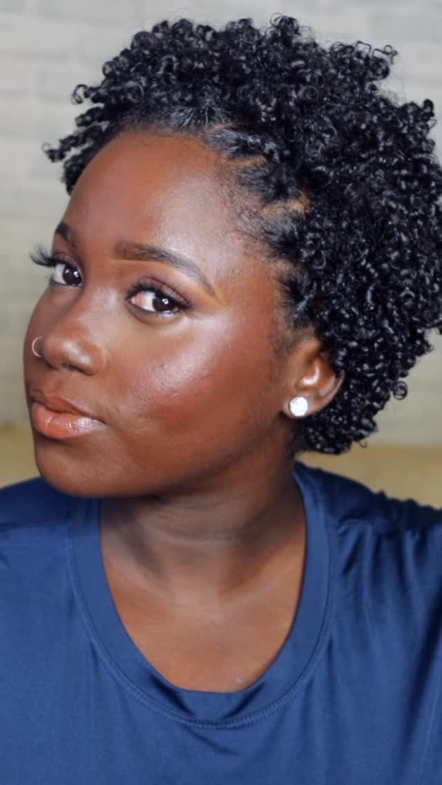 31 Black Hair Natural Hairstyles for Every Length 6 Woman with short curly black natural hair wearing a blue t-shirt.