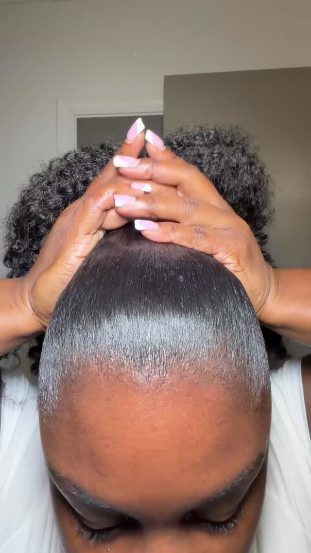 31 Black Hair Natural Hairstyles for Every Length 23 Slicked back front of black natural hair being styled by hands.