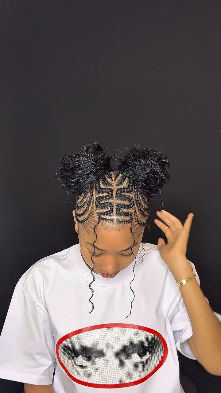 31 Black Hair Natural Hairstyles for Every Length 11 Person with black hair styled in two curly space buns and braided scalp patterns.