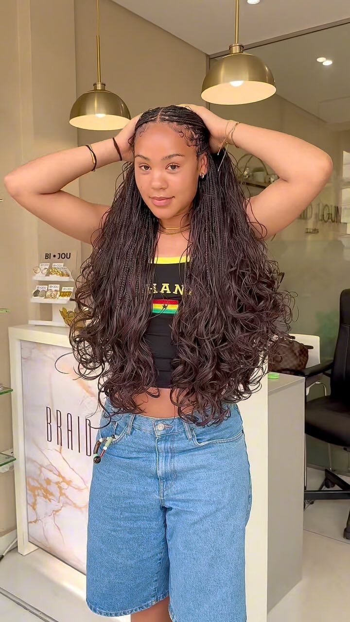 15 Braid Hairstyles for Thick Hair, From Bubble to Boho 15 Woman with long curly hair and small crown braids posing in a salon.