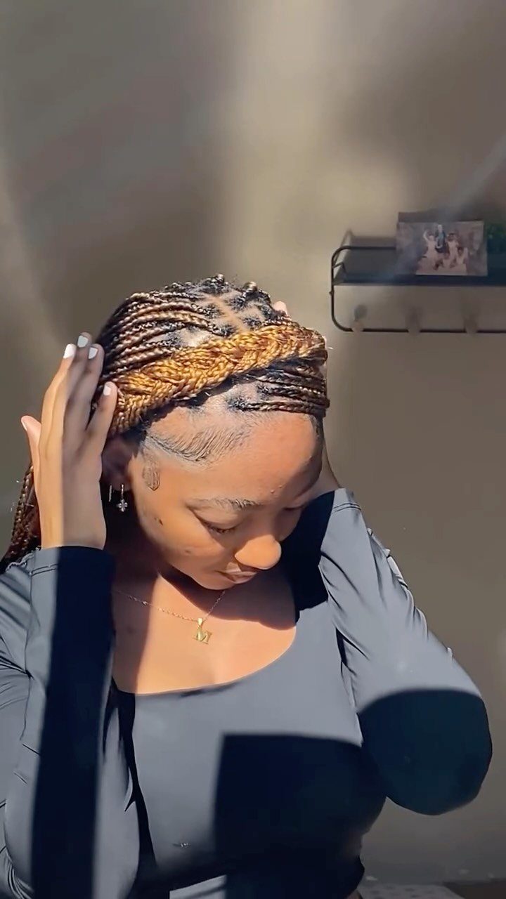 15 Braid Hairstyles for Thick Hair, From Bubble to Boho 2 Woman with brown knotless braids and a braided headband wearing a black shirt.
