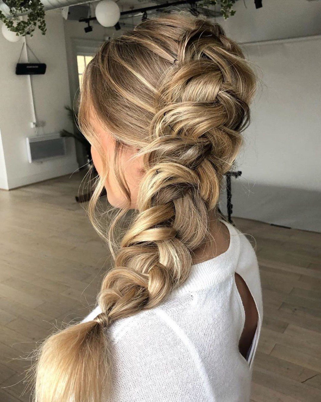 15 Braid Hairstyles for Thick Hair, From Bubble to Boho 13 Blonde woman with a voluminous, loosened pancaked braid trailing down her back.