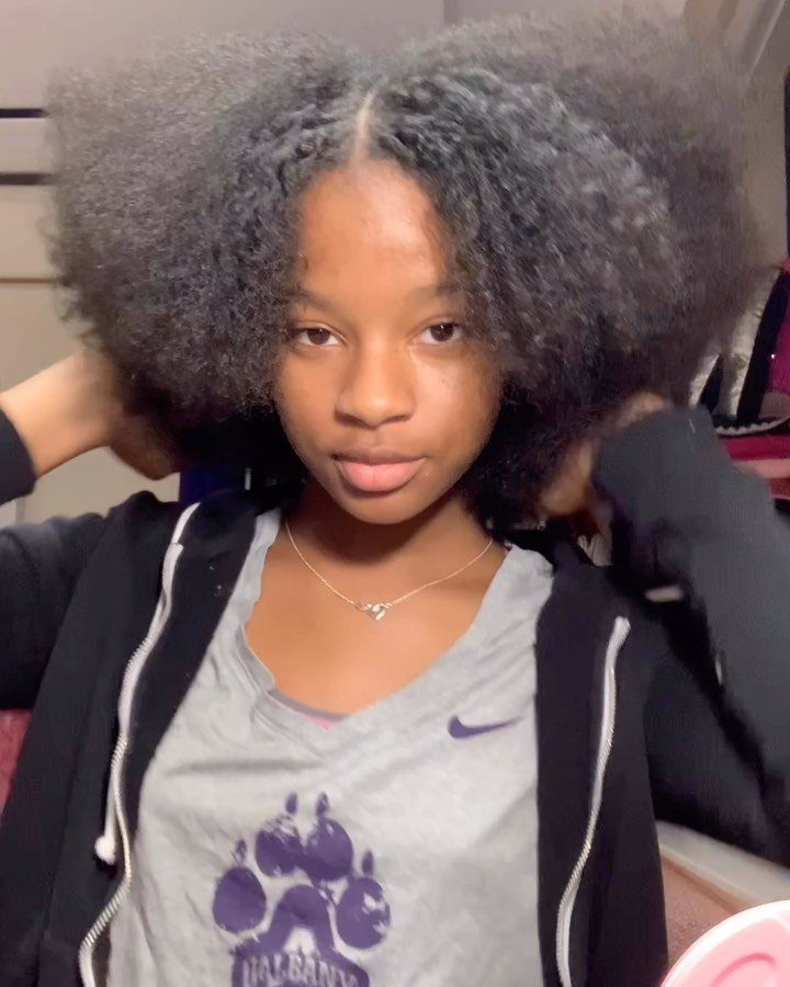 How to Style a Braid Out Afro: 5 Ideas for Every Length 1 Young woman with voluminous, fluffy black afro hair posing for a portrait.