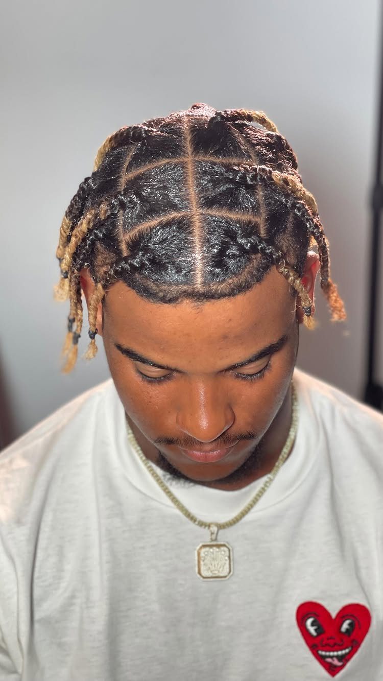 11 Braided Mens Hairstyles: Cornrows, Box Braids and More 5 Man with square-parted box braids transitioning from dark roots to light brown ends.
