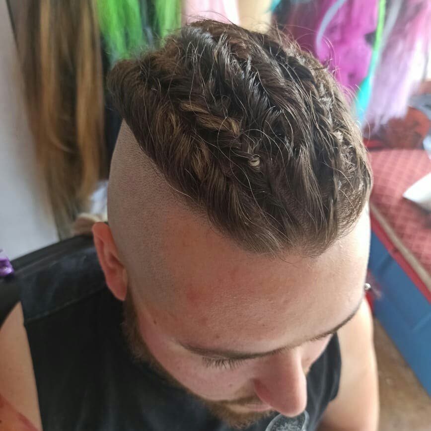 11 Braided Mens Hairstyles: Cornrows, Box Braids and More 11 Man with brown hair styled in braids on top and shaved sides.
