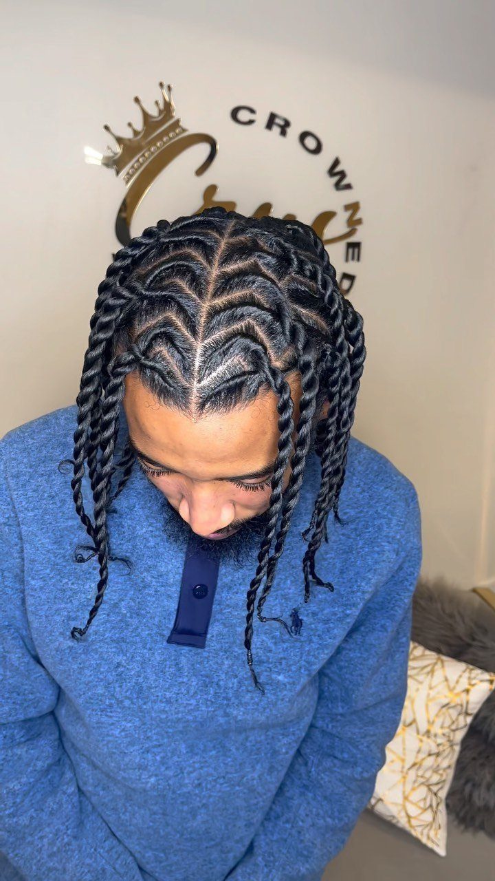 11 Braided Mens Hairstyles: Cornrows, Box Braids and More 7 Man with dark hair styled in thick twist braids wearing a blue sweater.