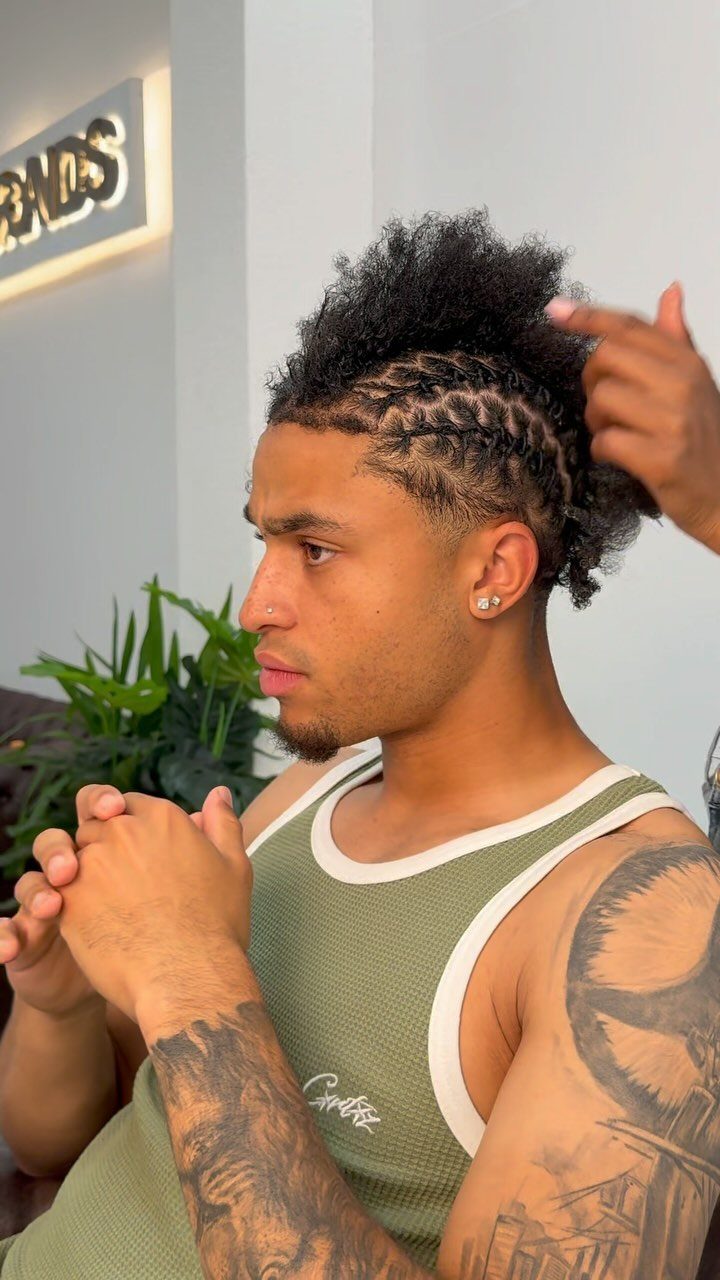 11 Braided Mens Hairstyles: Cornrows, Box Braids and More 9 Man with zigzag cornrows on the sides and a voluminous afro top.