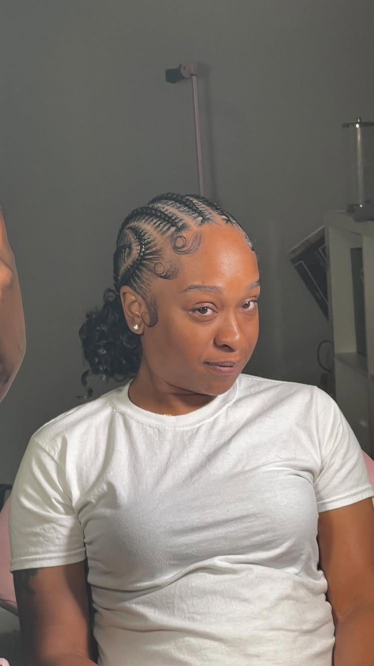 16 Braids Going Back with Curls: Styles to Try 10 Woman with cornrow braids leading back into a curly bun wearing white shirt