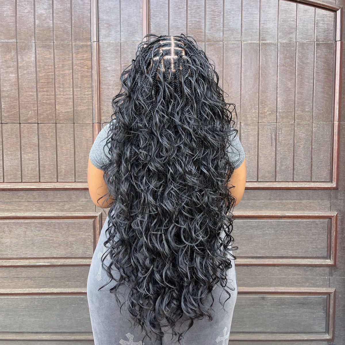 16 Braids Going Back with Curls: Styles to Try 9 Long black cornrow braids transitioning into voluminous loose curls on a person's back.