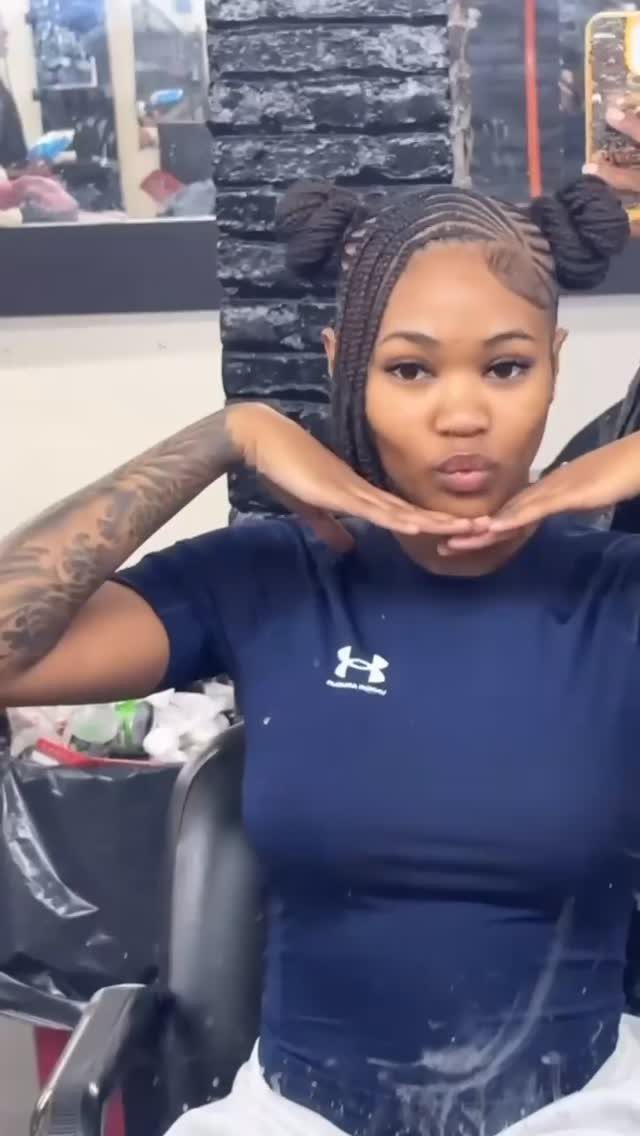 16 Braids Going Back with Curls: Styles to Try 2 Woman with cornrow braids styled into two braided space buns on her head.