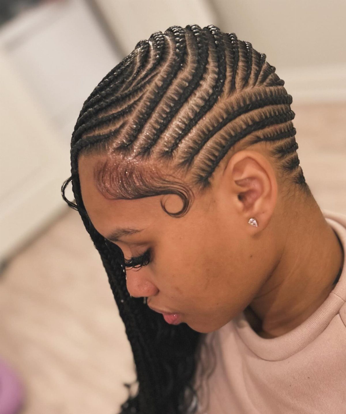 9 Braids with Natural Hair Only: Styles Without Extensions 2 Woman with black hair styled in curved lemonade braids flowing to one side.