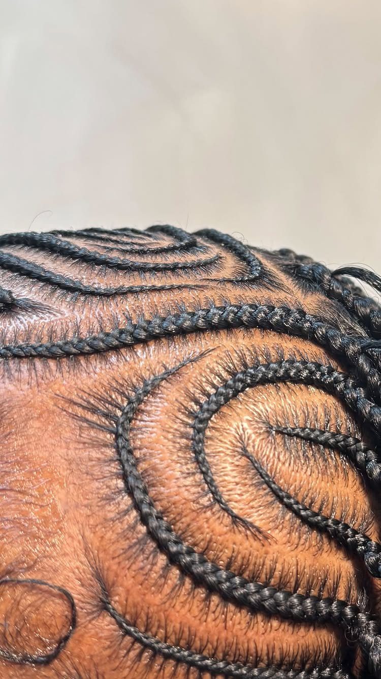 9 Braids with Natural Hair Only: Styles Without Extensions 9 Intricate curved black cornrows and braids styled in swirls on a brown scalp.