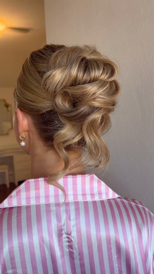 8 Ideas for a Bun with Curls, From High to Low 5 Blonde hair styled in a twisted bun with loose curls and pearl earring