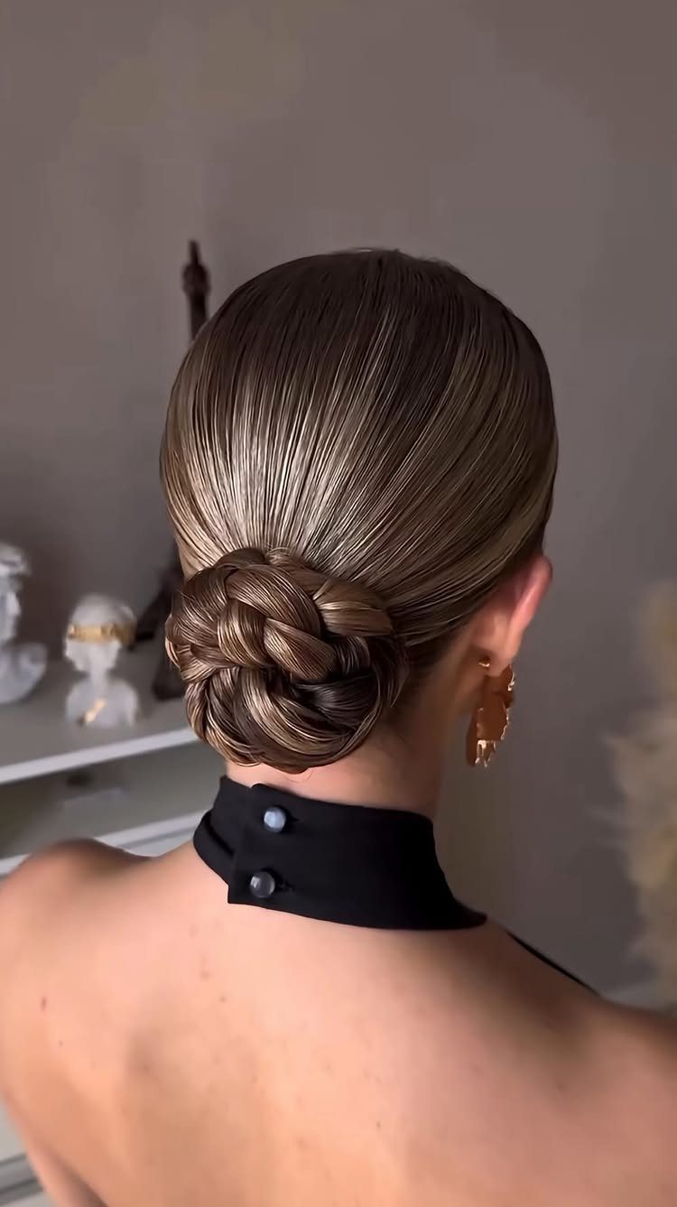 9 Business Casual Hairstyles for Women at the Office 4 Woman with a sleek braided updo bun and gold hoop earrings.