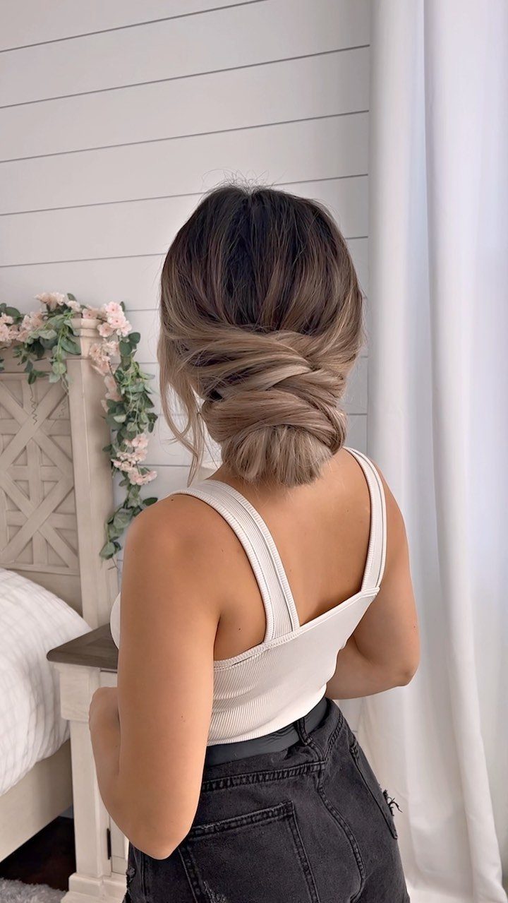7 Clean Look Hair Ideas for Sleek Buns and Ponytails 2 Woman from behind with brown hair styled in a neat coiled bun.