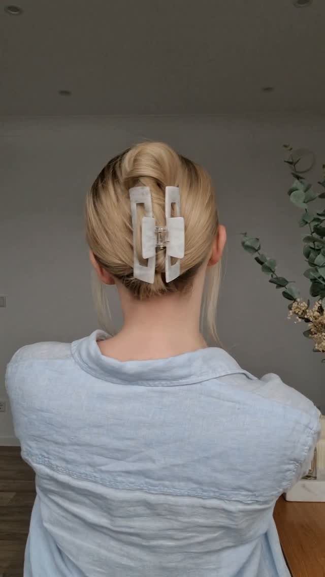 10 Clip Up Hairstyles with Claw Clips and Accent Clips 5 Blonde hair styled in a high ballerina bun secured with a white claw clip.