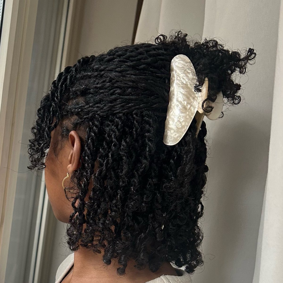 10 Clip Up Hairstyles with Claw Clips and Accent Clips 10 Curly black hair held up with a large white pearlescent claw clip.