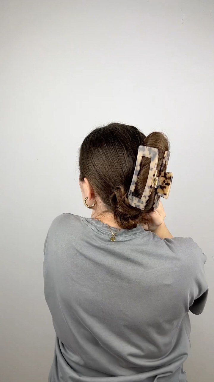 10 Clip Up Hairstyles with Claw Clips and Accent Clips 7 Brown hair styled in a twist secured with a marbled beige claw clip.