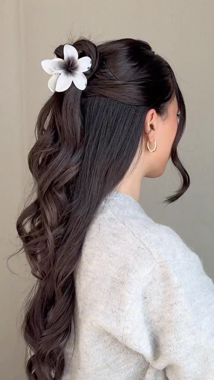 10 Clip Up Hairstyles with Claw Clips and Accent Clips 3 Woman with wavy brown hair styled in a half-up look with a flower clip