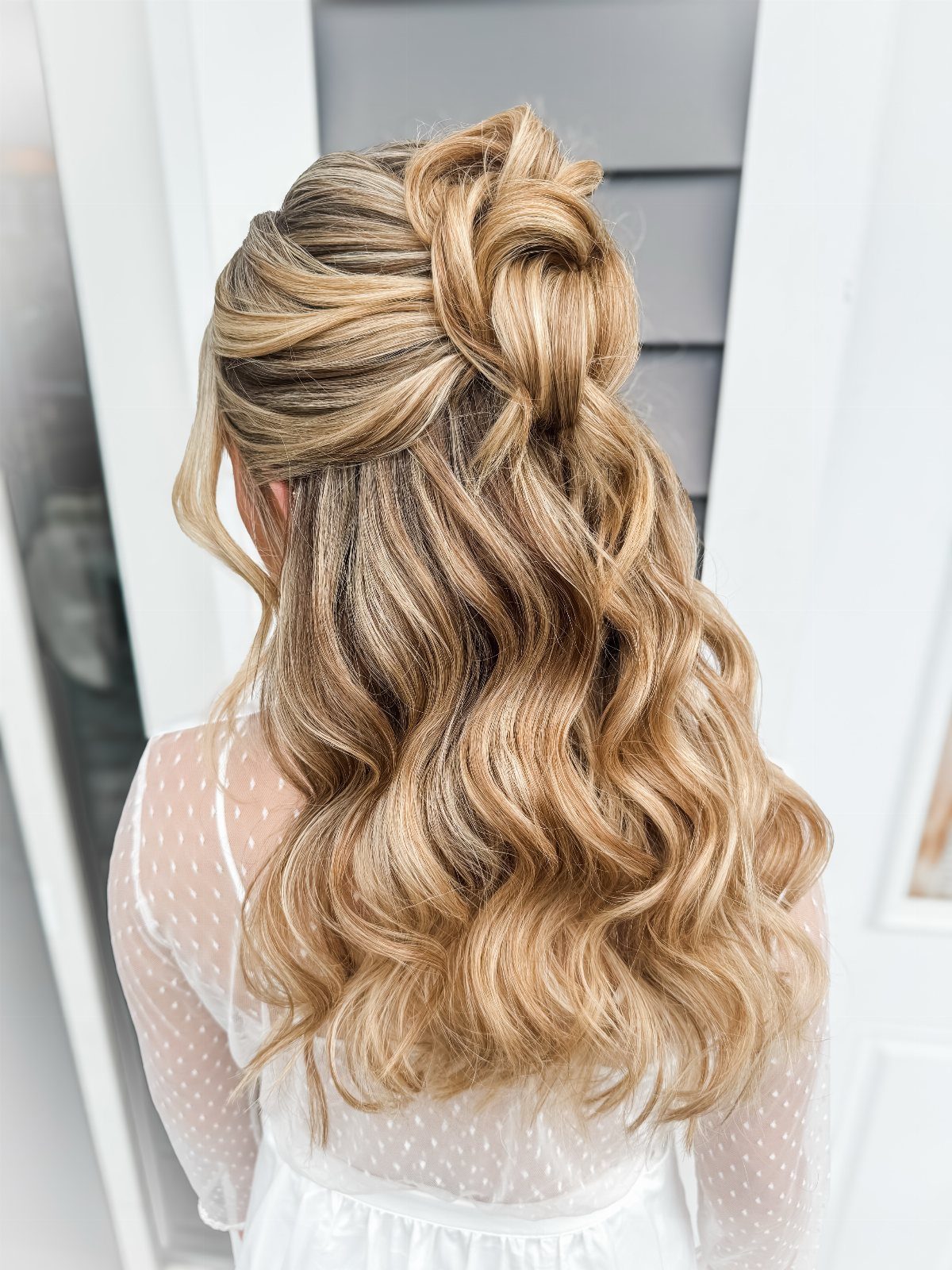 10 Clip Up Hairstyles with Claw Clips and Accent Clips 9 Blonde wavy hair styled in a half-up twisted knot half-updo from behind.