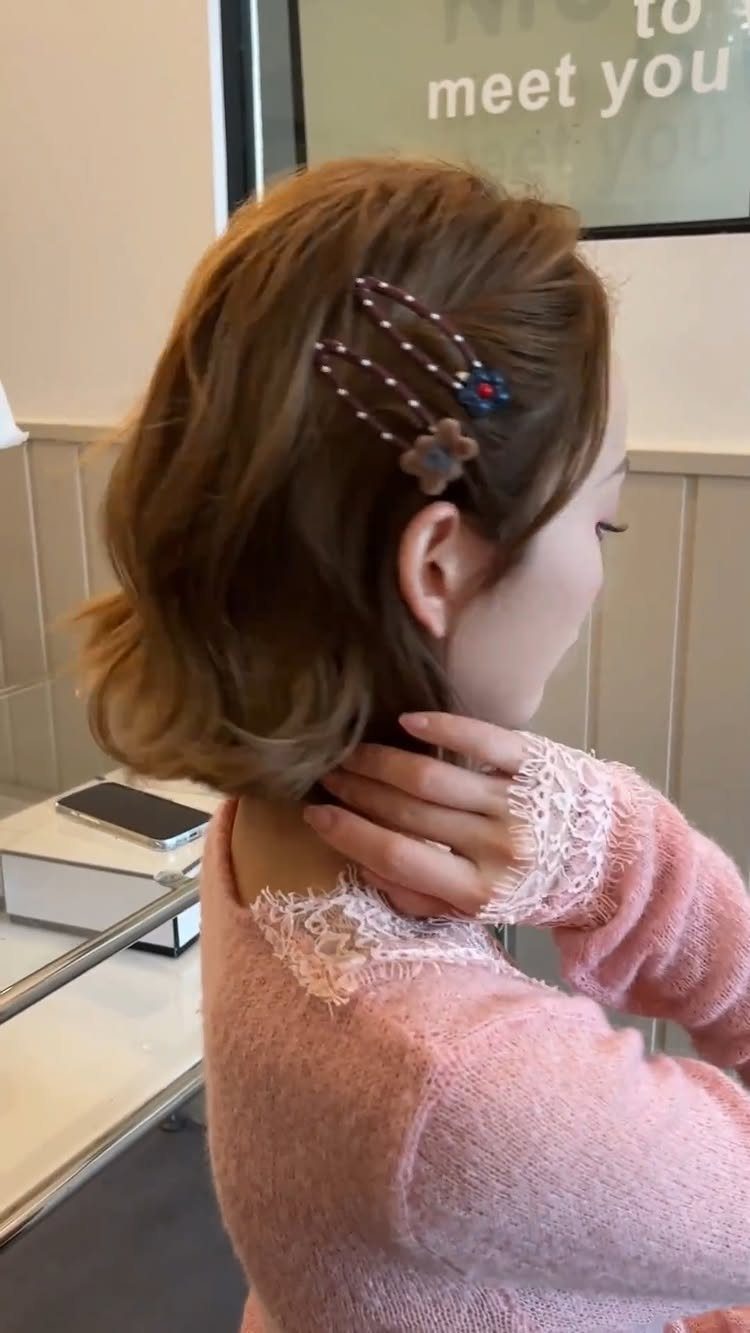 10 Clip Up Hairstyles with Claw Clips and Accent Clips 6 Woman with brown hair wearing pearl and flower accent clips in her hair.
