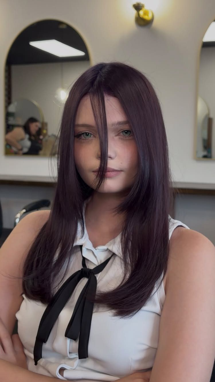 Color Hair for Morena: 8 Shades That Flatter Brown Skin 4 Woman with long straight mauve purple hair wearing a white blouse and bow.