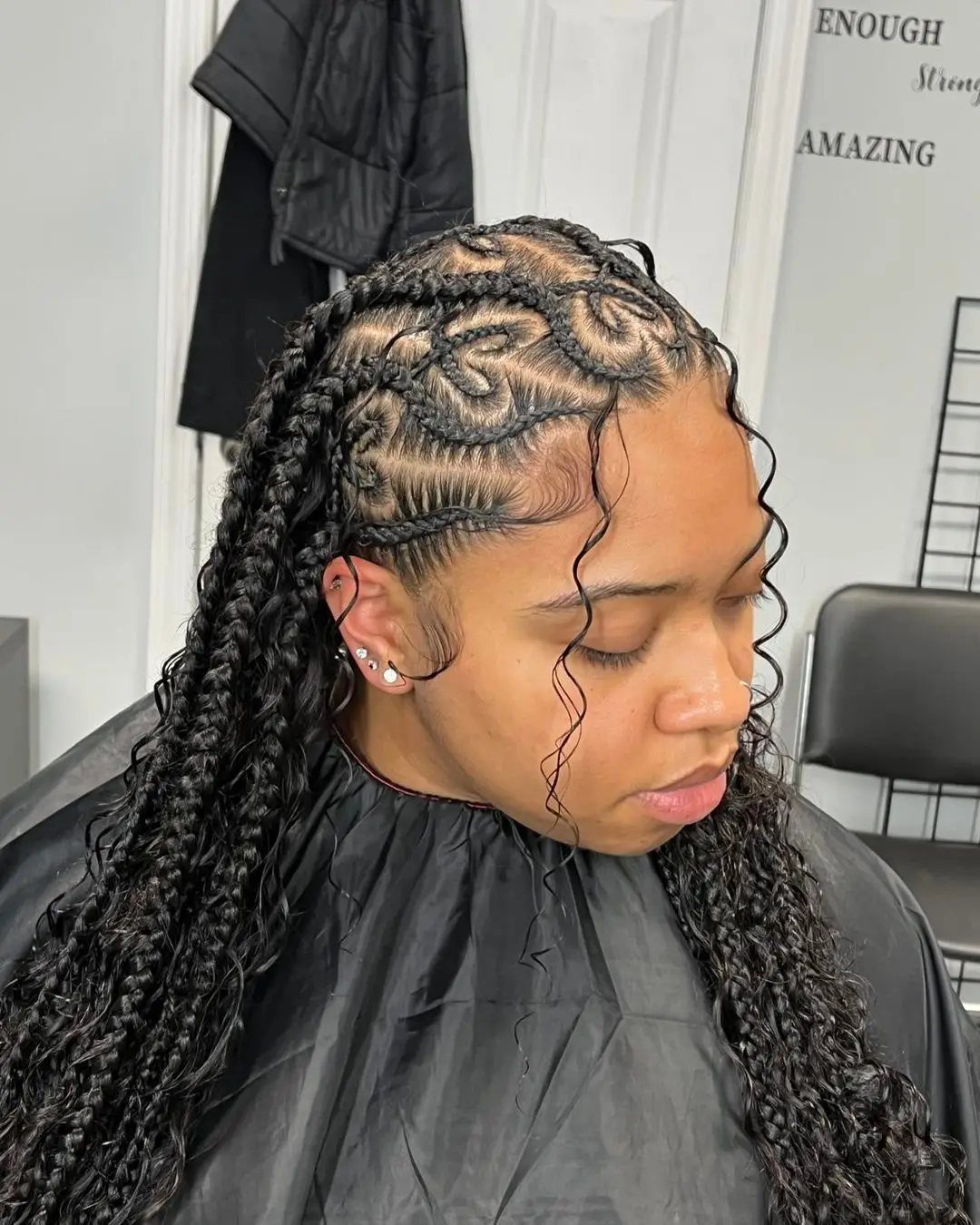 Cornrows Braids with Curls: 13 Ideas for Every Style 9 Woman with black cornrow braids featuring heart patterns and long curly ends.