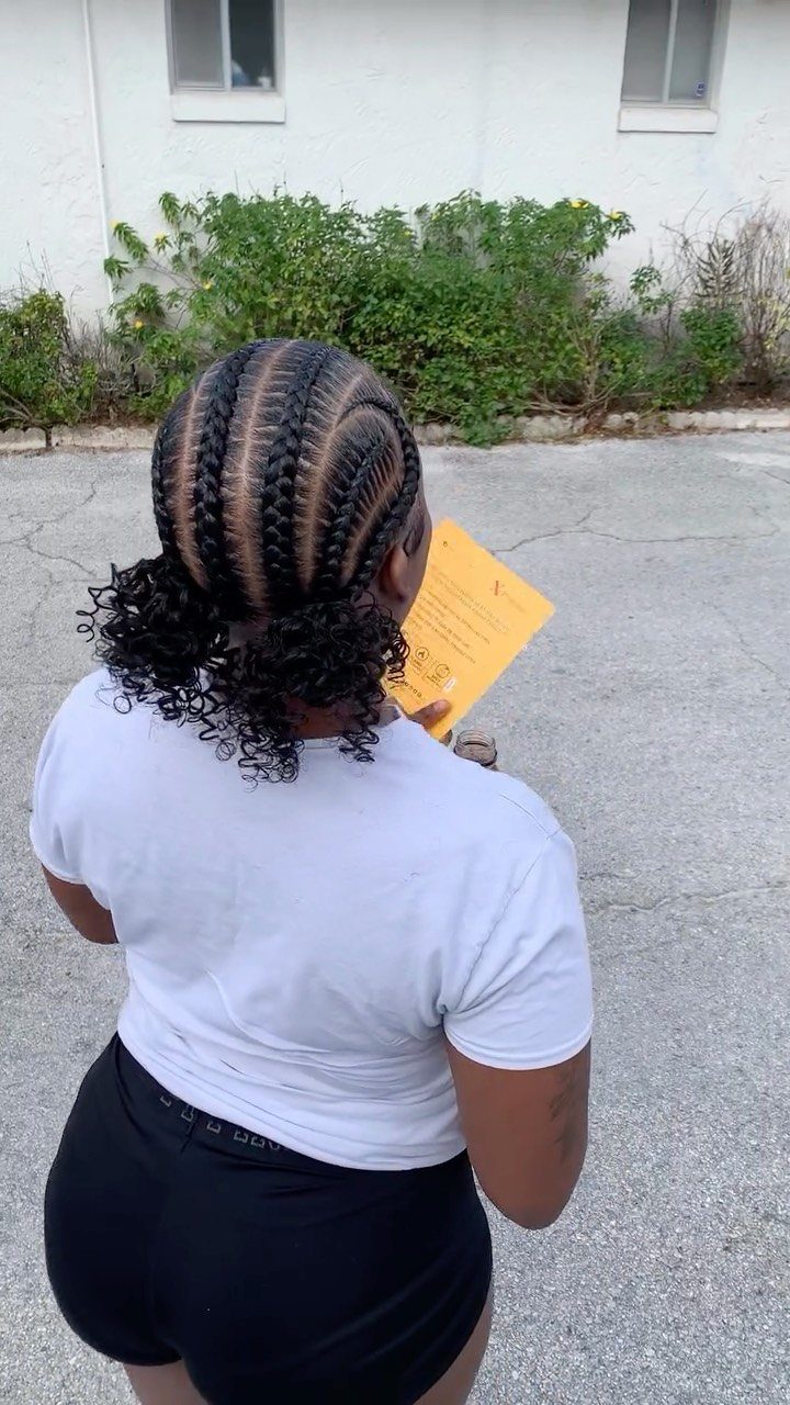 Cornrows Braids with Curls: 13 Ideas for Every Style 2 Woman with thick stitch cornrow braids ending in voluminous black curls from behind.