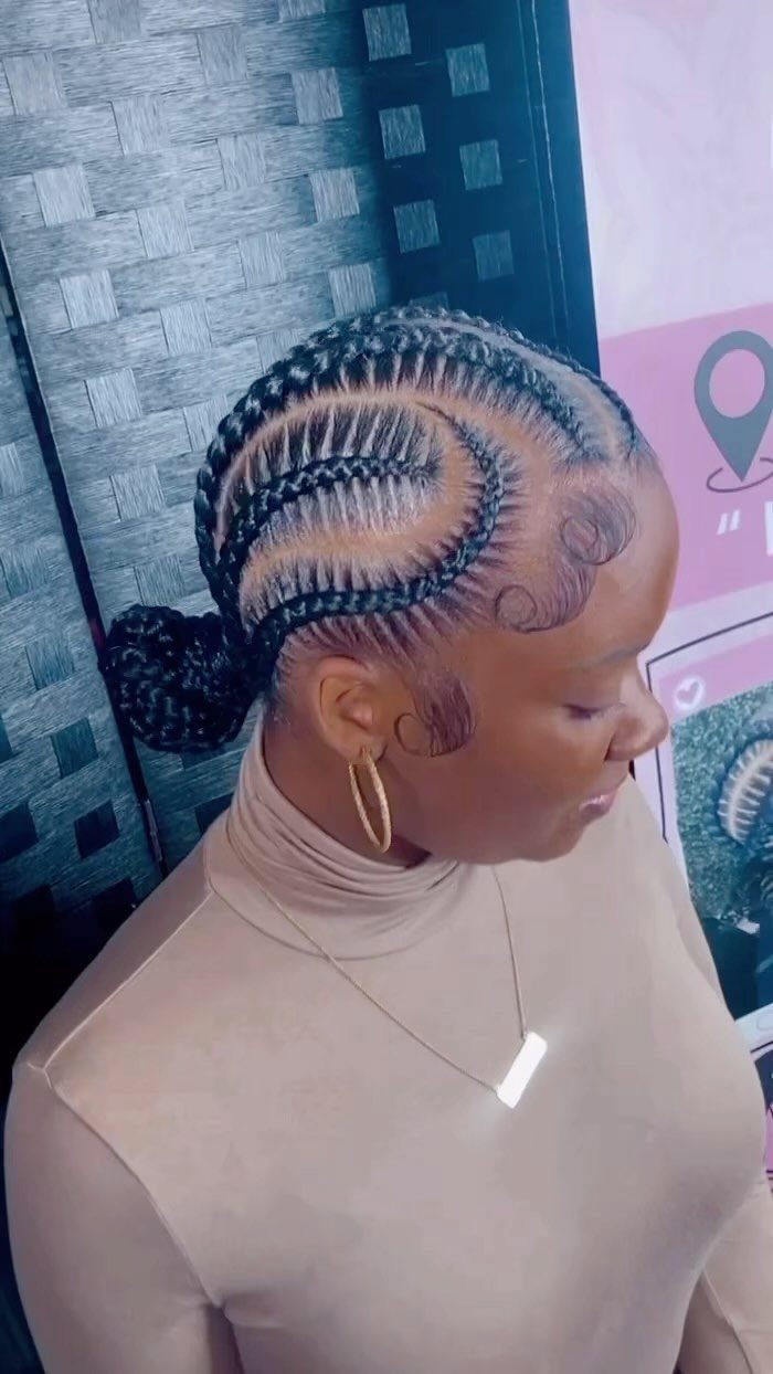 Cornrows Braids with Curls: 13 Ideas for Every Style 5 Woman with curved cornrow braids gathered into a sleek low bun hairstyle.