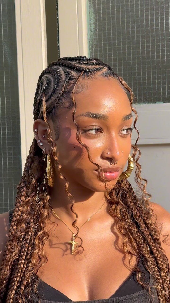 Woman with curved cornrow patterns transitioning into long brown box braids.