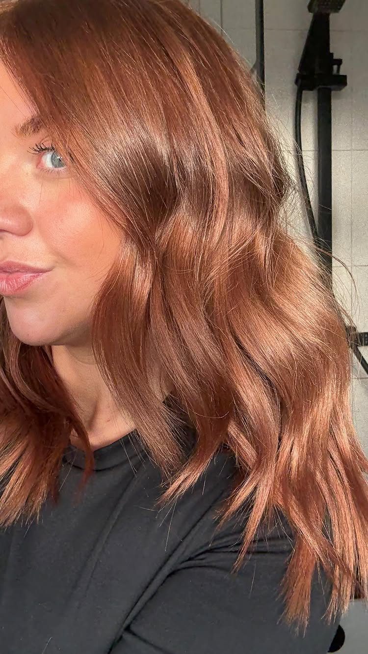 Cowboy Hair Color Ideas: 6 Copper Shades to Try 3 Woman with long, wavy copper-brown hair posing for a close-up portrait.