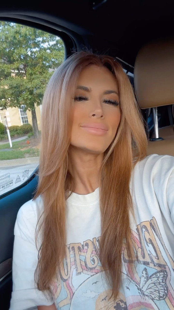 Cowboy Hair Color Ideas: 6 Copper Shades to Try 2 Woman with long copper hair posing inside a car wearing a white t-shirt